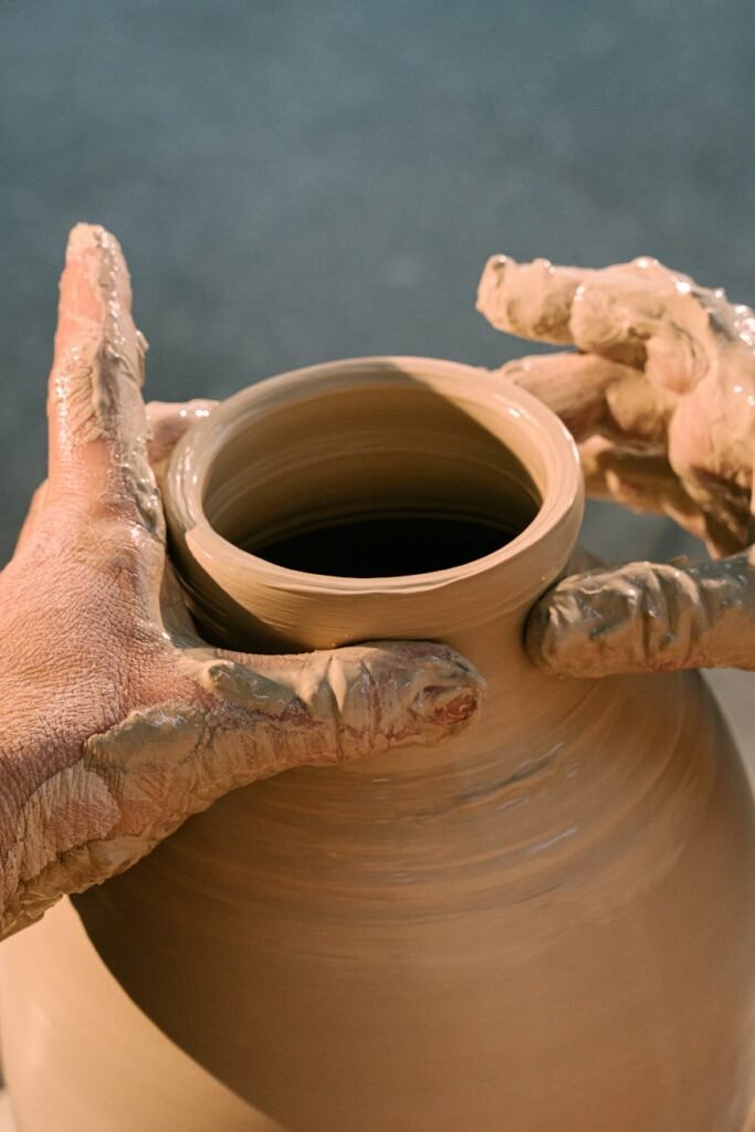 pexels-photo-4706134-4706134 Close-up of hands molding a clay pot, highlighting the art of pottery making.